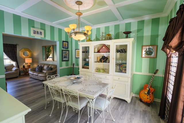 dining area with dark hardwood / wood-style flooring, an inviting chandelier, coffered ceiling, and crown molding