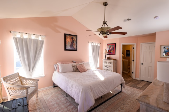 bedroom featuring ceiling fan, lofted ceiling, ensuite bathroom, and light hardwood / wood-style flooring