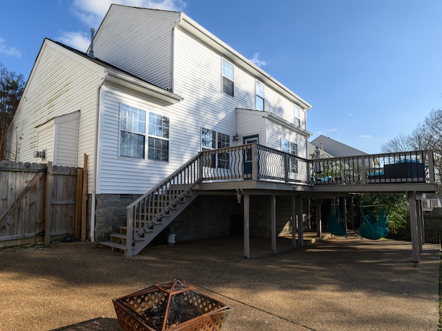 rear view of house with a deck and an outdoor fire pit