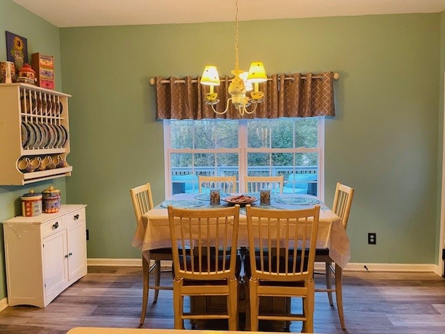 dining space featuring dark wood-type flooring and a notable chandelier