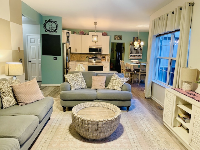 living room featuring light hardwood / wood-style floors and a notable chandelier