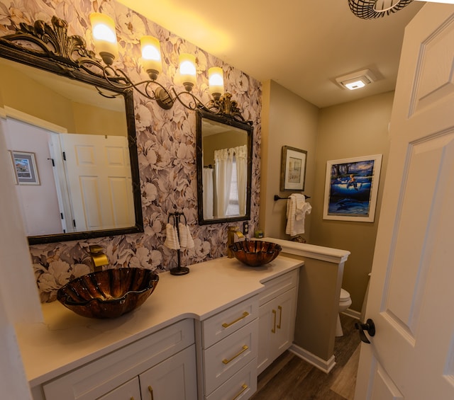 bathroom with hardwood / wood-style floors, vanity, and toilet