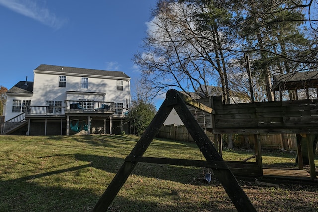 rear view of property featuring a yard and a deck