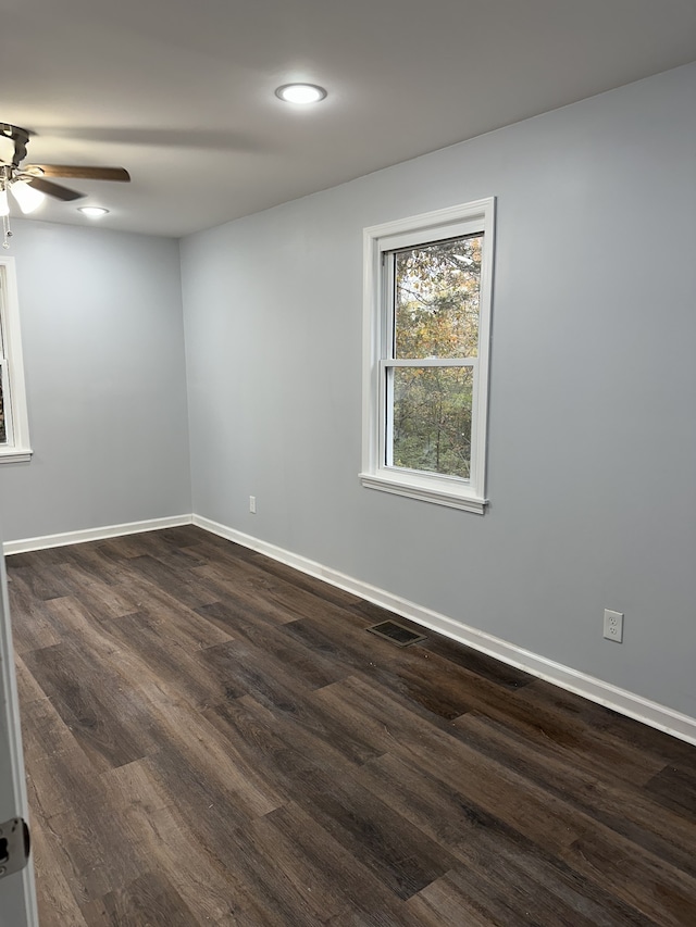 spare room featuring dark wood-type flooring and ceiling fan