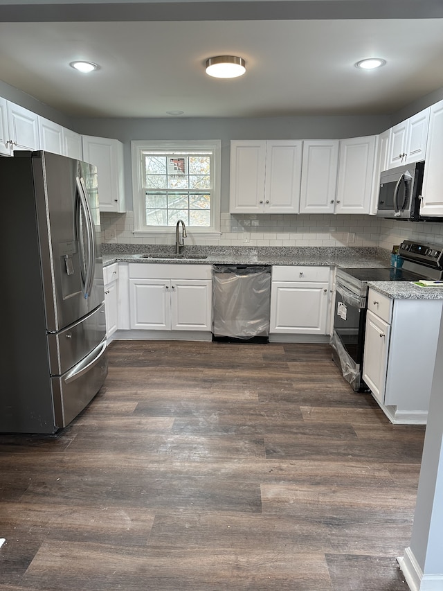 kitchen featuring tasteful backsplash, white cabinetry, sink, stainless steel appliances, and dark wood-type flooring