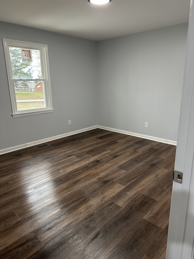 unfurnished room featuring dark wood-type flooring