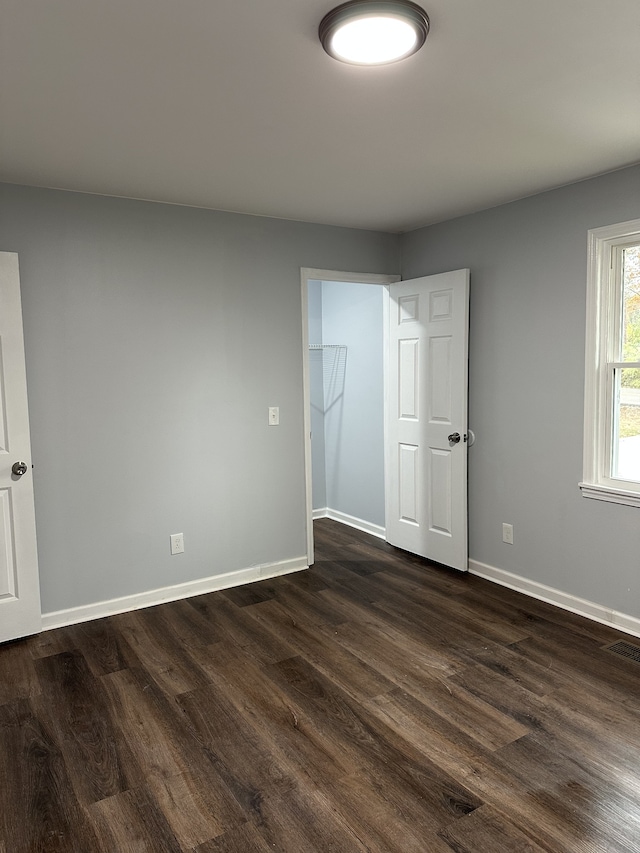 unfurnished room with dark hardwood / wood-style floors