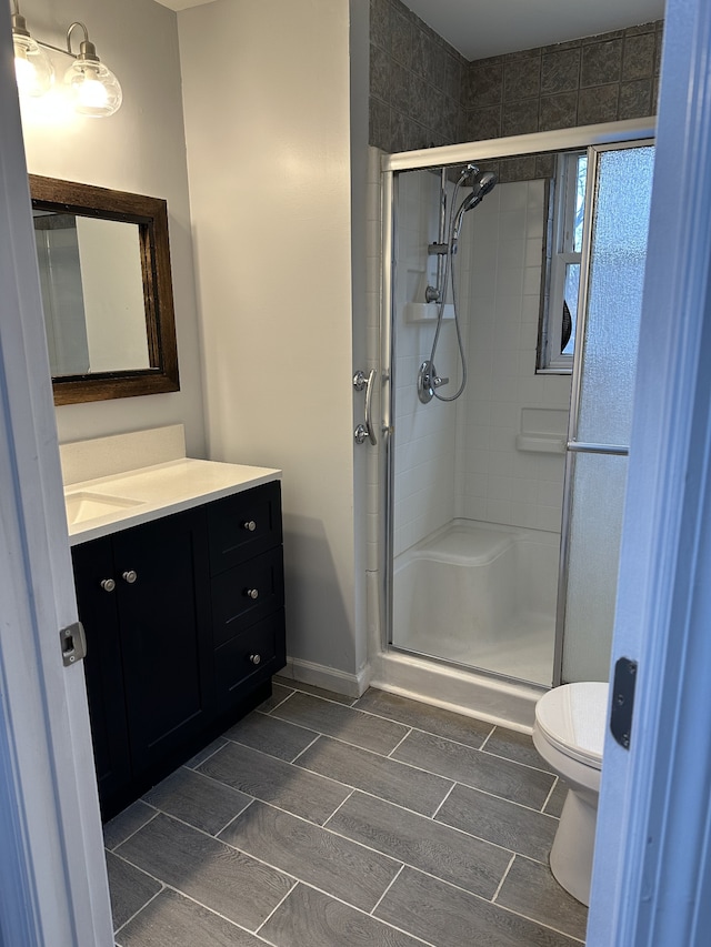 bathroom with vanity, toilet, and an enclosed shower