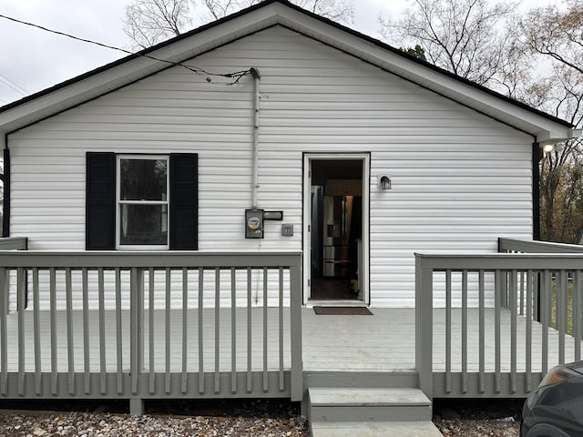 rear view of property featuring a wooden deck