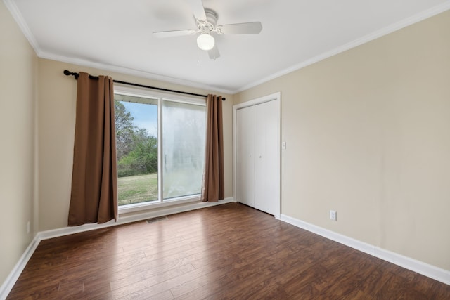 spare room featuring dark hardwood / wood-style flooring, ceiling fan, and crown molding