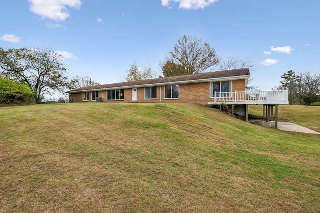 back of property with a lawn and a wooden deck