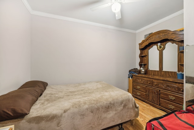 bedroom with ceiling fan, crown molding, and hardwood / wood-style flooring