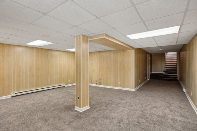 basement featuring carpet flooring, a paneled ceiling, and baseboard heating