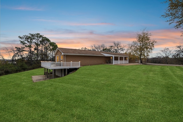 yard at dusk with a patio and a wooden deck