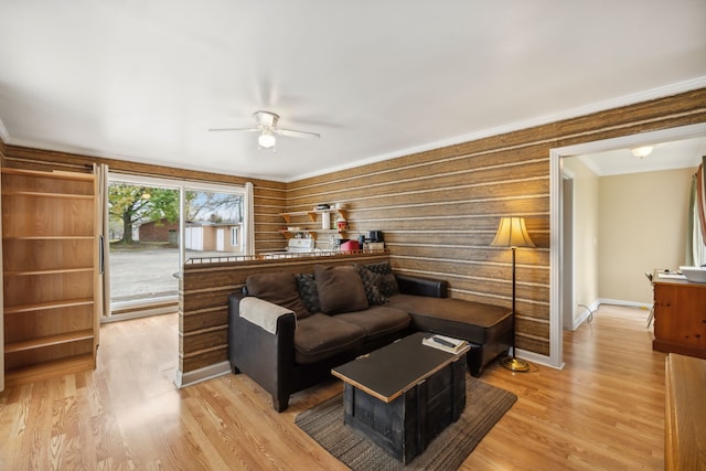 interior space with ceiling fan, light wood-type flooring, ornamental molding, and access to outside