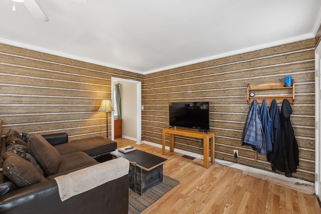 living room with light hardwood / wood-style floors, ceiling fan, and ornamental molding