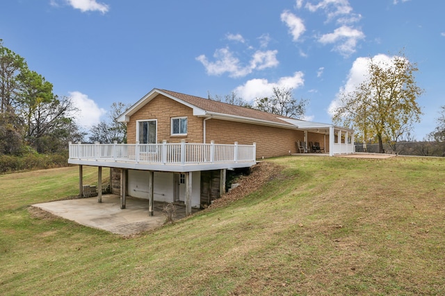 rear view of house featuring a wooden deck, a yard, a patio, and a garage