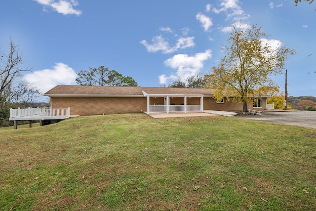 back of property with a patio area, a yard, and a deck