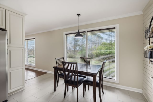 tiled dining area featuring a wealth of natural light and ornamental molding