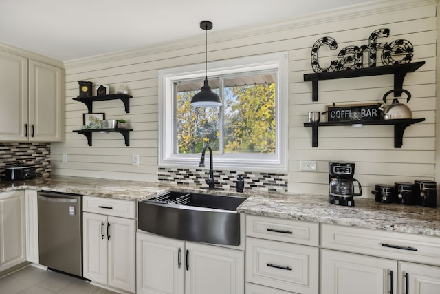 kitchen featuring dishwasher, wood walls, sink, hanging light fixtures, and light stone countertops