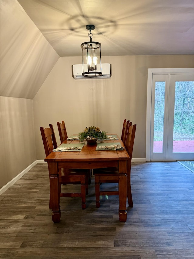 dining space with a chandelier, dark hardwood / wood-style flooring, a wall mounted AC, and lofted ceiling