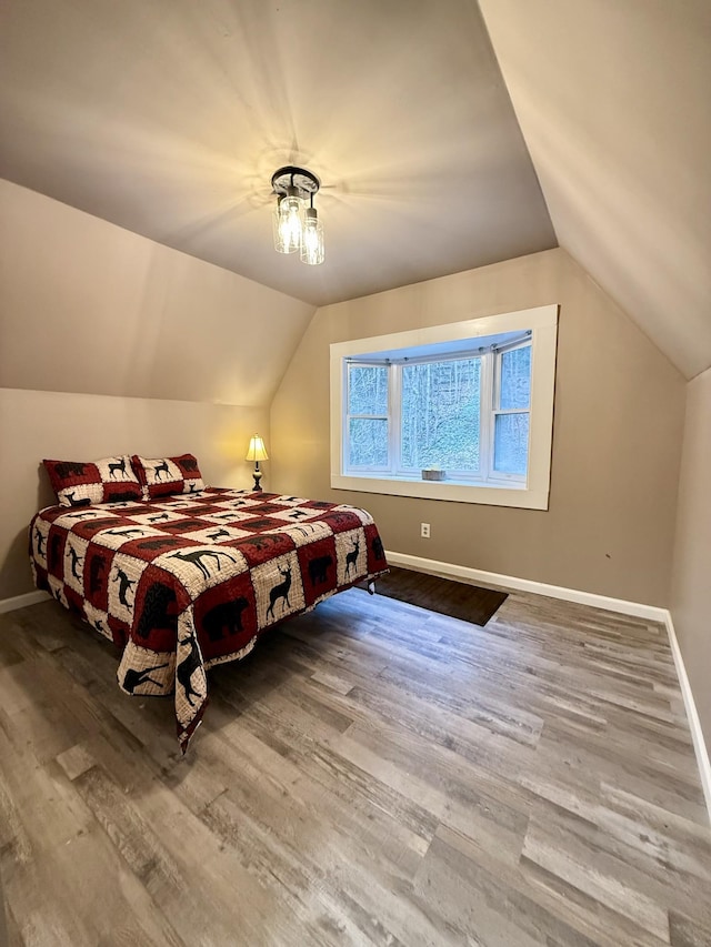 bedroom featuring hardwood / wood-style flooring and lofted ceiling