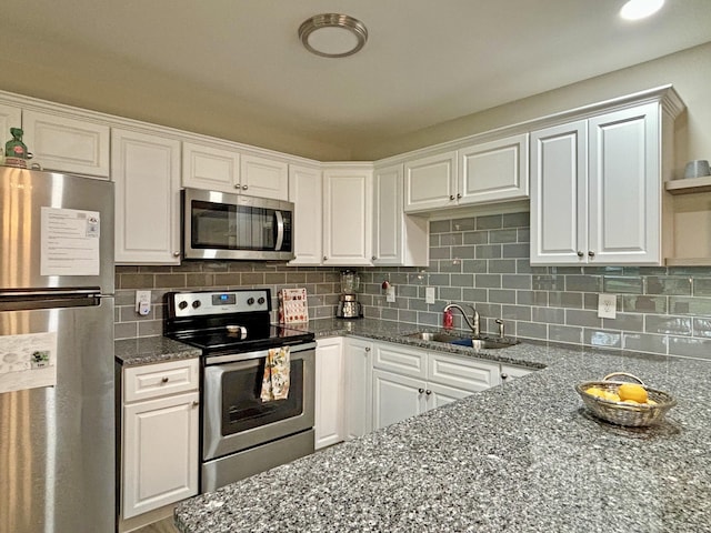 kitchen featuring decorative backsplash, white cabinetry, sink, and appliances with stainless steel finishes