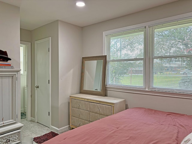 bedroom featuring light colored carpet and multiple windows