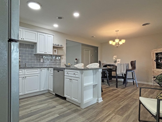 kitchen featuring kitchen peninsula, white cabinetry, light wood-type flooring, and appliances with stainless steel finishes