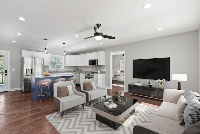 living room with ceiling fan and dark hardwood / wood-style flooring