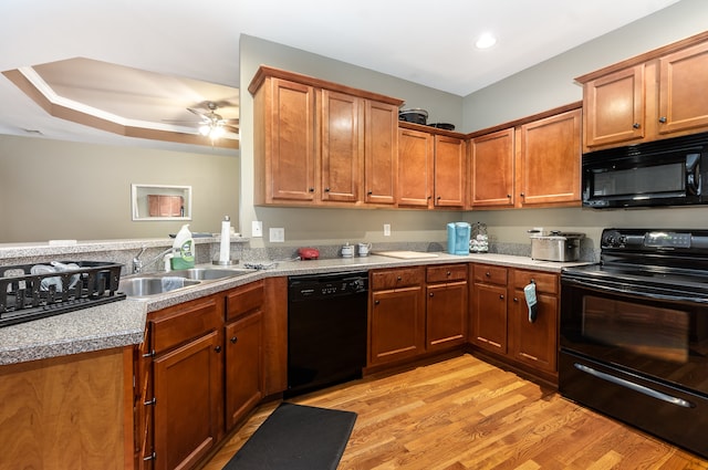 kitchen featuring black appliances, sink, ceiling fan, light hardwood / wood-style floors, and kitchen peninsula