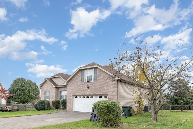 view of front of house featuring central air condition unit, a front yard, and a garage