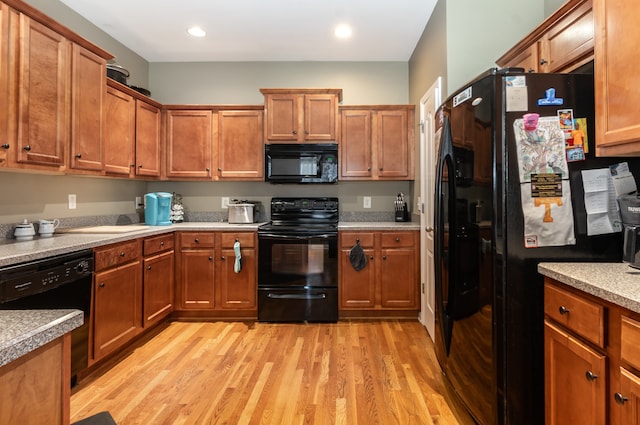 kitchen with black appliances and light wood-type flooring