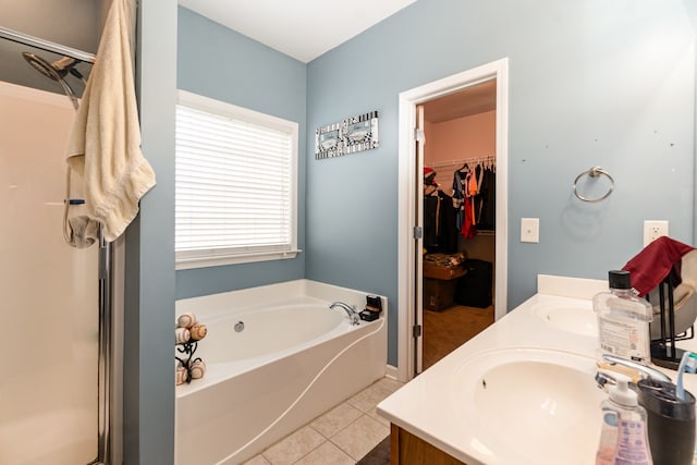 bathroom with tile patterned flooring, vanity, and plus walk in shower