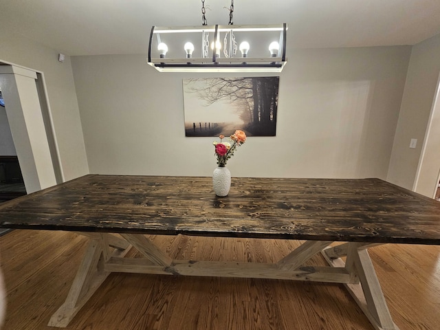 dining room with hardwood / wood-style floors and an inviting chandelier