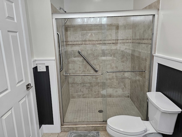 bathroom featuring toilet, tile patterned flooring, and walk in shower