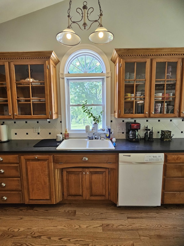 kitchen featuring decorative backsplash, dishwasher, decorative light fixtures, and sink