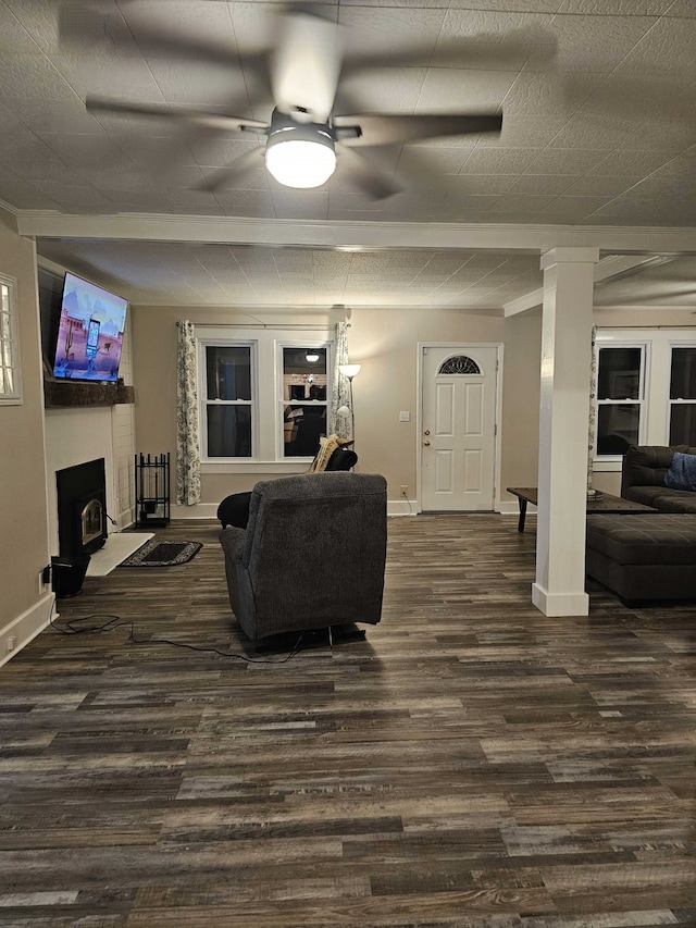 living room featuring ceiling fan, dark hardwood / wood-style flooring, and a wood stove