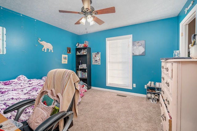 bedroom featuring carpet flooring, ceiling fan, and a textured ceiling