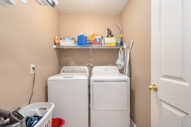 clothes washing area featuring washer and clothes dryer and a textured ceiling