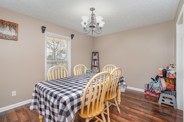 dining area featuring a notable chandelier, dark hardwood / wood-style floors, and a textured ceiling