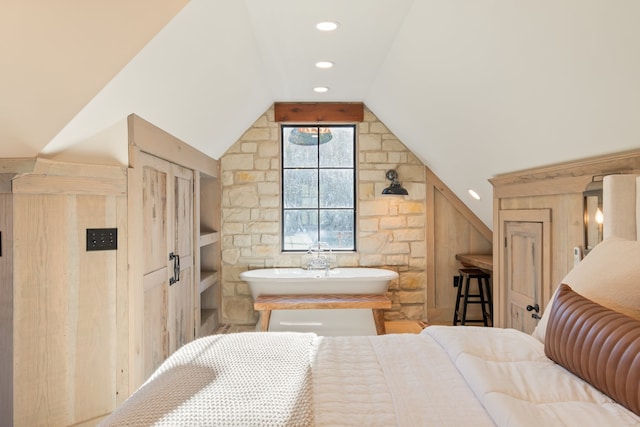 bedroom featuring lofted ceiling, sink, and wooden walls