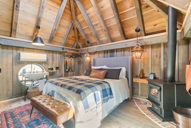 bedroom featuring a wood stove, lofted ceiling with beams, a wall mounted AC, wooden walls, and hardwood / wood-style flooring