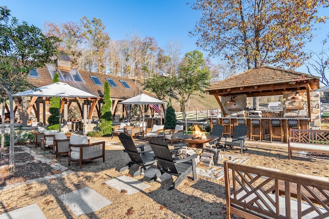 view of patio with a gazebo, exterior bar, and an outdoor fire pit