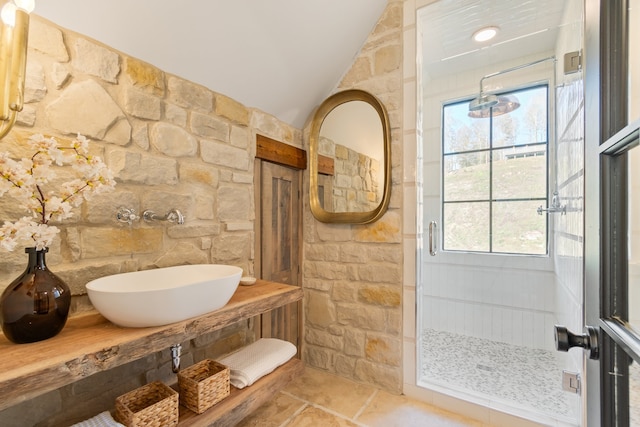 bathroom featuring a healthy amount of sunlight, vaulted ceiling, and walk in shower