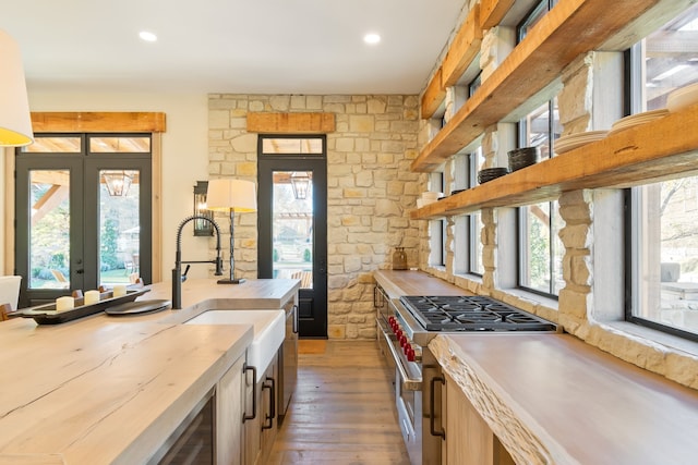 kitchen with french doors, sink, dark hardwood / wood-style floors, butcher block countertops, and stainless steel stove