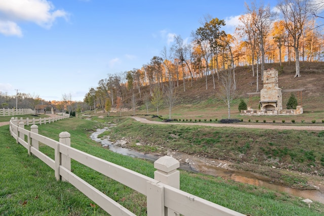 view of yard featuring a rural view and an outdoor stone fireplace