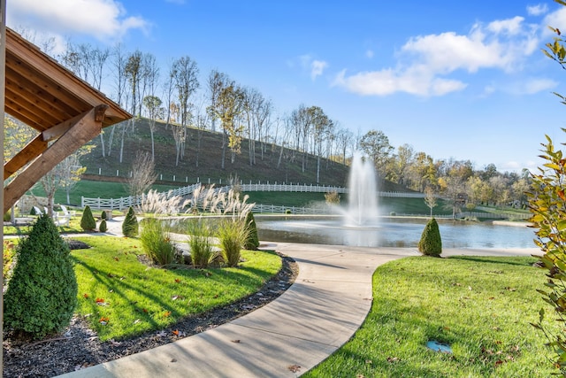 surrounding community with a lawn and a water view