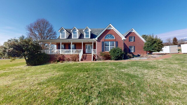 cape cod house featuring covered porch and a front yard