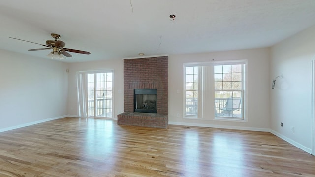 unfurnished living room with light hardwood / wood-style floors, a brick fireplace, and ceiling fan